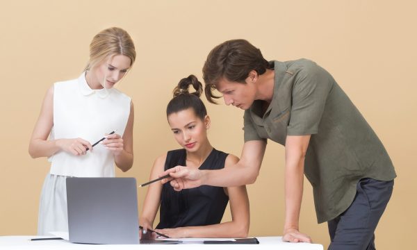 Tuteur accompagnant deux jeunes en alternance devant un ordinateur